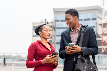young african business people checking their phone outdoor
