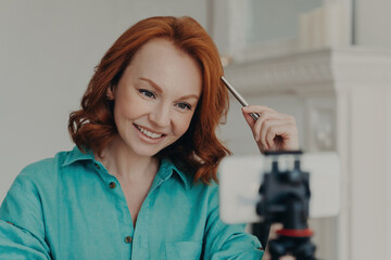 Happy redhead vlogger records webcam videos, gives advice, teaches languages as online teacher....