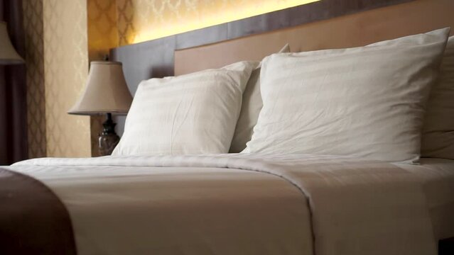 Cozy bedroom with bed in hotel. Comfort white bed with two pillows. pan shot of empty hotel room