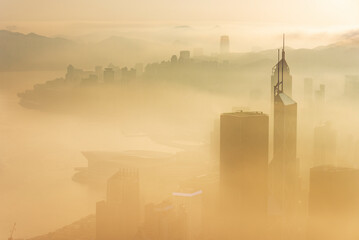 Skyscraper in downtown district of Hong Kong city in fog under sunrise