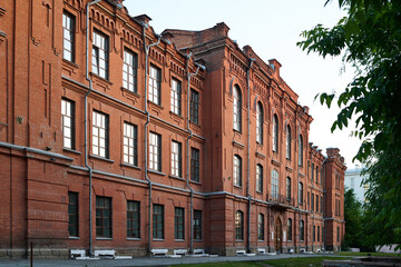 Perspective of long red brick building or historical monument consisting of three storeys standing...