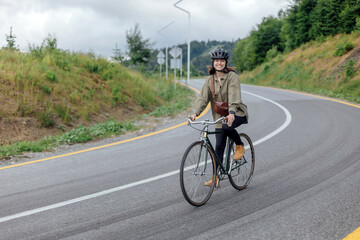 Young woman cyclist enjoy the beautiful view on green mountains trail