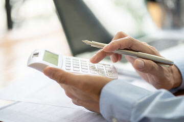 Businessman Accountant analyzing investment charts Invoice and pressing calculator buttons over documents. Accounting Bookkeeper Clerk Bank Advisor And Auditor Concept