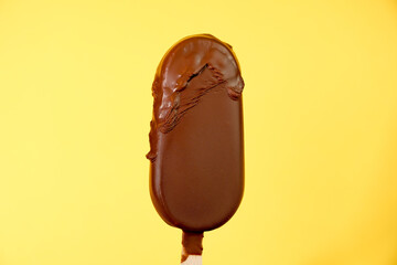chocolate ice cream melts on yellow background