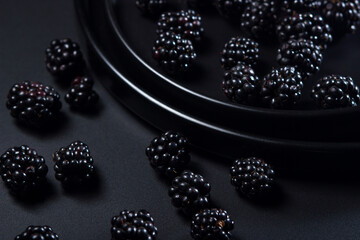 Blackberries on a black plate on a black background