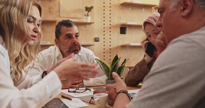 Senior manager explaining business proposal to his colleague, office resting area, cafe bar. Camera trucking movement