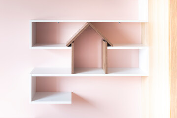 Etagère en forme de maison pour enfant dans une chambre rose