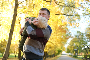 Father playing with son in autumn park