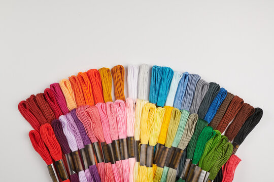 Set of multi-colored floss thread yarn, all for cross stitching and embroidery isolated on white background.