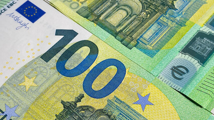 Close-up of part of a one hundred euro note. Single currency of the European Union. European currency. 100 euro. Cash banknotes. Financial business background concept. - obrazy, fototapety, plakaty
