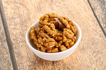 Cracked unshelled walnut in the bowl
