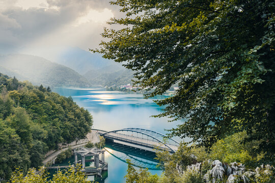 Aerial shot of Barcis lake and its dam. Emerald water, sky with clouds
