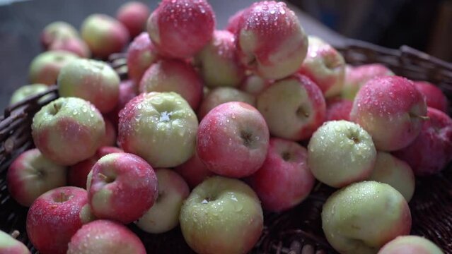 Fresh red apples on a wooden table in a basket are spinning