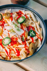 Bowl of french fries topped with sauce