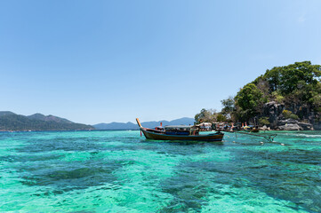 Obraz premium Wooden boat in emerald sea on summer during sunny day at Lipe Island