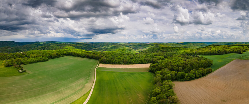Aerial drone panoramic view in summer of Thayatal National Park on a cloudy day with fields in the foreground and the Czech Republic in the distance, Hardegg, Lower Austria, Austria.