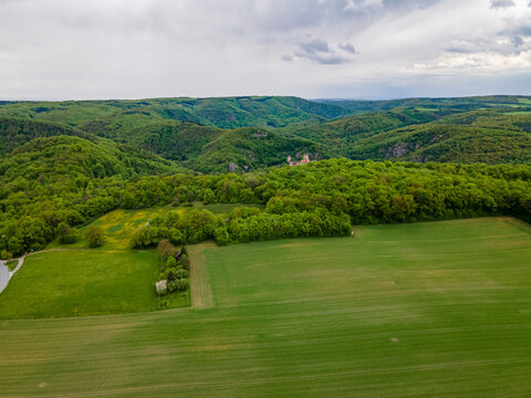 Aerial drone view in summer of Thayatal National Park with fields and parts of Hardegg Castle in the foreground and Czech Republic in the distance under storm clouds, Hardegg, Lower Austria, Austria.