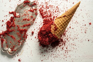 Delicious scoop of ice cream on a cone near a sprinkling of red shavings