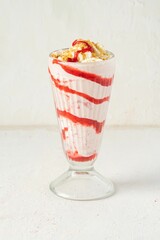 Glass of a creamy strawberry milkshake topped with whipped cream