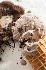 Delicious scoop of chocolate ice cream on a cone near a sprinkling of chocolate shavings
