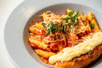 a pasta dish topped with cheese and herbs on a white plate