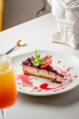 Piece of delicious berry cheesecake on a plate on the table