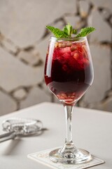 Vertical shot of a glass of delicious sangria with mint garnish on the table