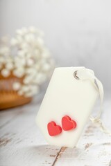 Heart-shaped polymer tag with small red hearts on it