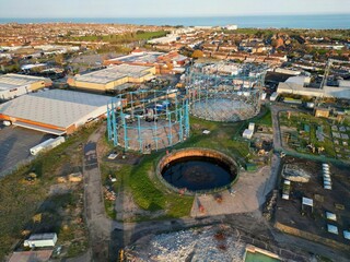 Aerial view of a column-guided gas holder surrounded by industrial buildings