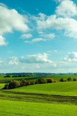 Rolgordijnen Stunning rural landscape with a green field and a blue sky with white clouds. Bavaria, Haimhause. © Zoltan Major/Wirestock Creators