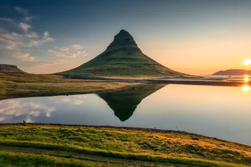 Fototapete Kirkjufell Volcanic Kirkjufell mountain with lake reflection and traveler man standing during sunrise at Iceland