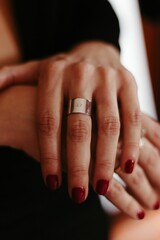Shot of a woman's hand wearing a silver ring with two letters written on it