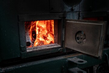 the fire is burning into the stove, as a person watches