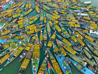 Bangladesh - 15 February 2023: Aerial view of floating market of seasonal fruits on the boats in Kaptai Lake, Rangamati, Bangladesh.