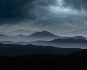 Landscape of rocky mountains on a dark cloudy day with overcast