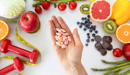 Hand of european adult lady recommends a lot of pills, vitamins, nutritional supplements