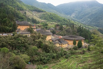 Aerial view of Tulou cluster surrounded by lush greenery. Fujian Province, China.