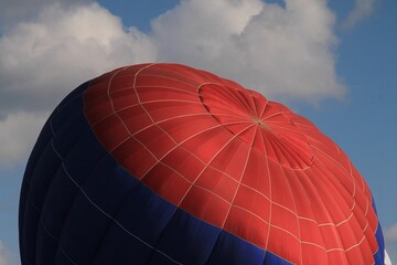 Obraz premium Red-blue hot air balloon against a cloudy sky