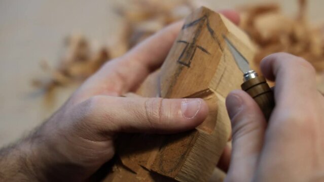 Closeup video of wood carving process of a human figure with a knife