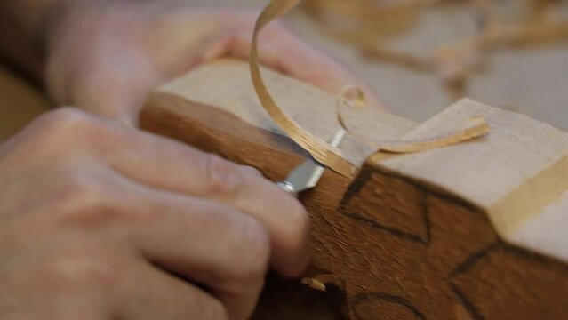 Closeup video of wood carving process of a human figure with a knife