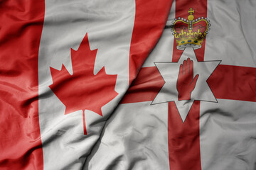 big waving realistic national colorful flag of canada and national flag of northern ireland .
