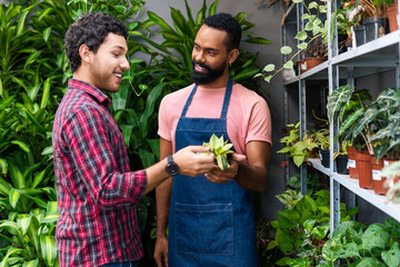 Seller shows products to customer in landscaping shop.