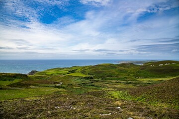 Scenic landscape with a lush green field against  a tranquil lake in Lag, Ireland