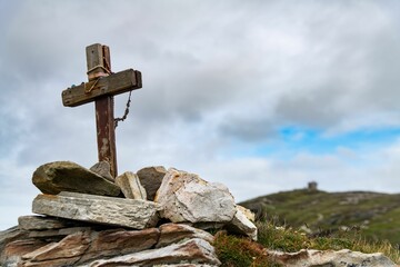 Wooden cross prominently displayed on top of a rocky mountain landscape