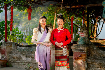 Obraz premium Close up portrait of two beautiful Asian woman stand in front of old or ancient architecture or building look like temple of northern Thailand.