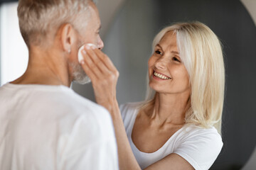 Home Skin Care. Mature Couple Making Anti-Aging Beauty Routine In Bathroom Together