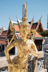 Closeup of a golden statue in The Temple of the Emerald Buddha in Bangkok
