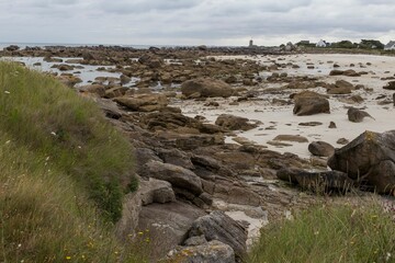 Landscape of a rocky shore surrounded by the water under a cloudy sky in the countrysid0e