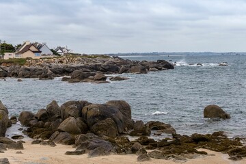 Landscape of a rocky shore surrounded by the water under a cloudy sky in the countrysid0e