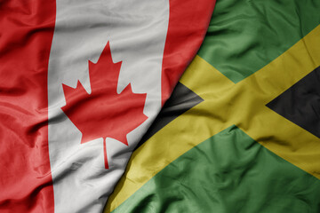 big waving realistic national colorful flag of canada and national flag of jamaica .